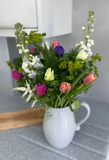 Jug with colourful spring flowers